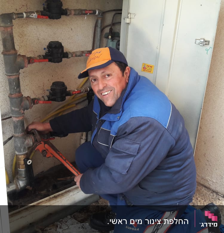 איש עם מפתח צינורות מתקן צנרת מים